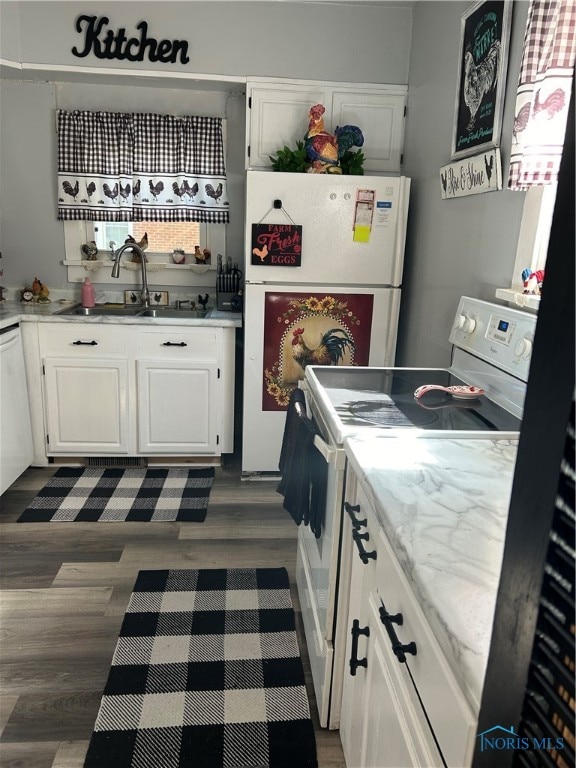 kitchen with dark hardwood / wood-style floors, white cabinets, sink, and white appliances