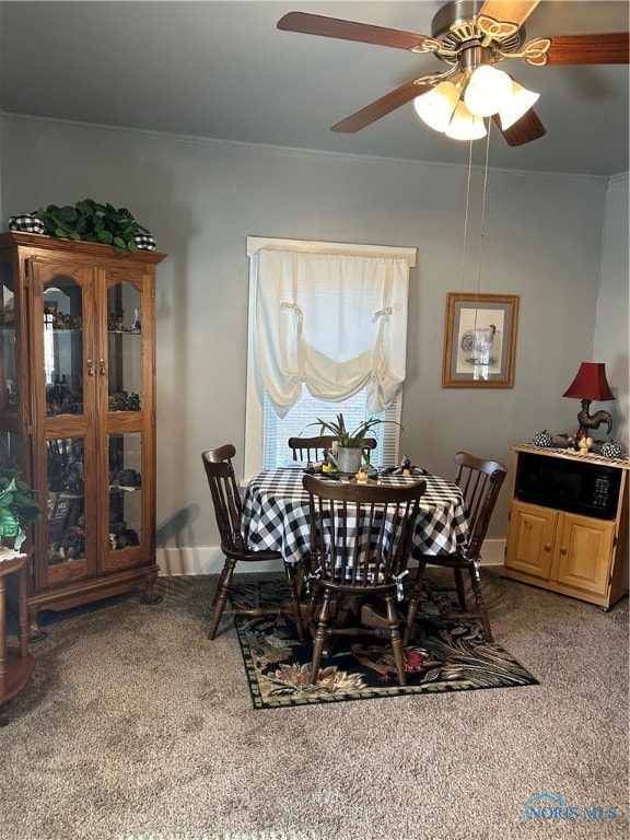 dining space featuring ceiling fan and carpet