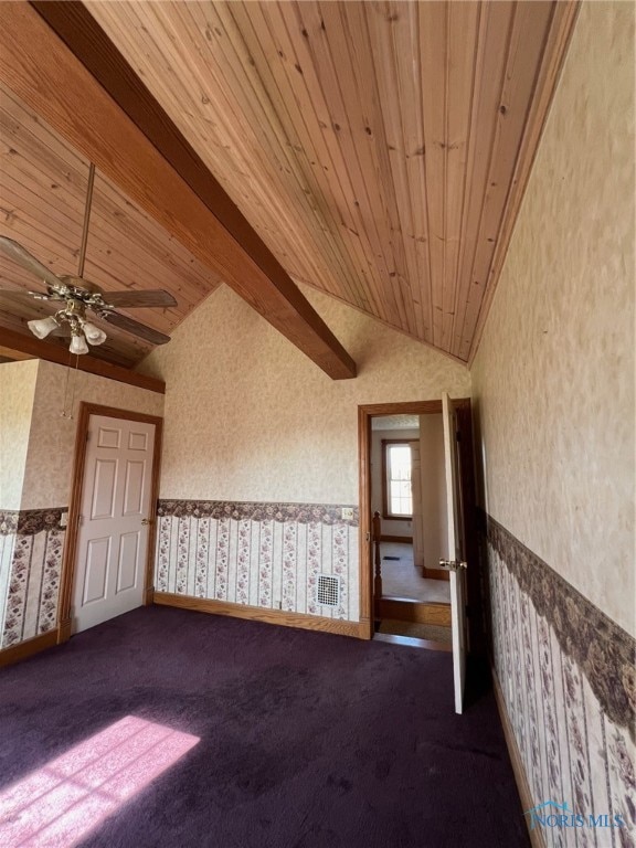 spare room with lofted ceiling with beams and ceiling fan