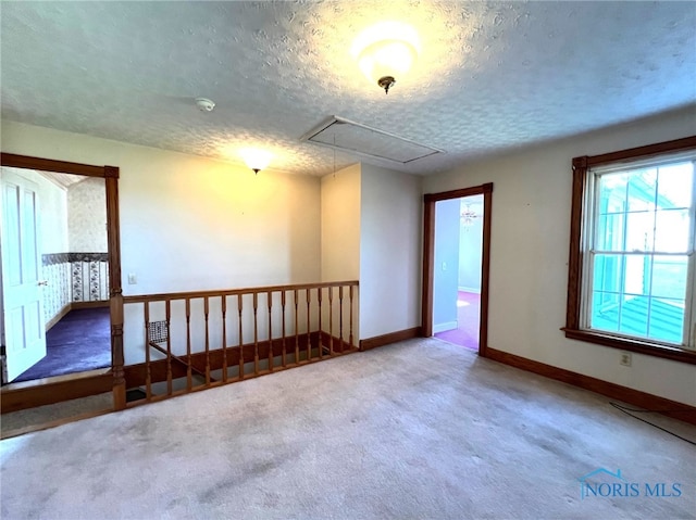 carpeted spare room with a textured ceiling