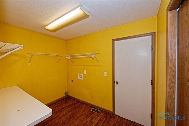 laundry area featuring hookup for a washing machine, dark wood-type flooring, and a textured ceiling