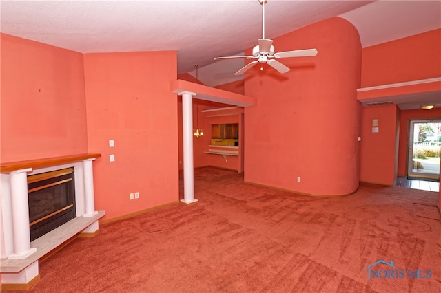 unfurnished living room featuring carpet, vaulted ceiling, a fireplace, and ceiling fan