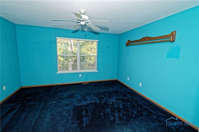 carpeted spare room with a textured ceiling and ceiling fan