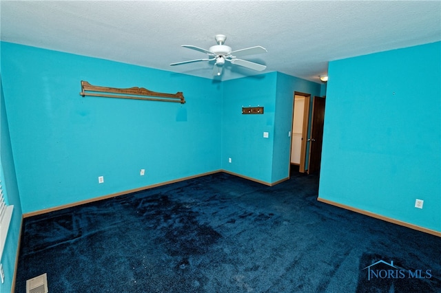 carpeted empty room with ceiling fan and a textured ceiling