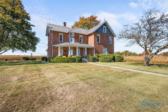 view of front of house with covered porch and a front lawn