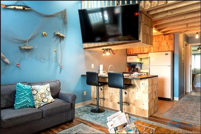 living room featuring beam ceiling and light wood-type flooring