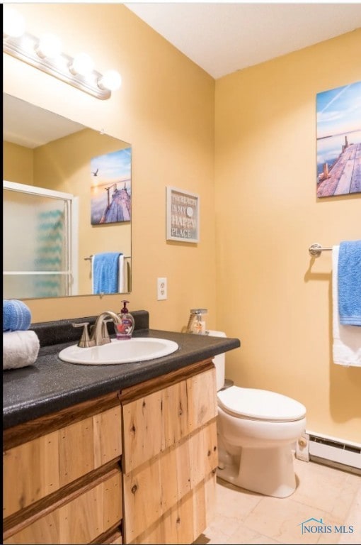 bathroom featuring a shower with shower door, toilet, tile patterned floors, baseboard heating, and vanity