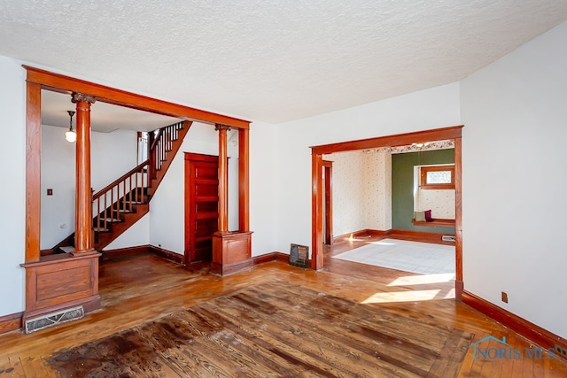 empty room with wood-type flooring and a textured ceiling