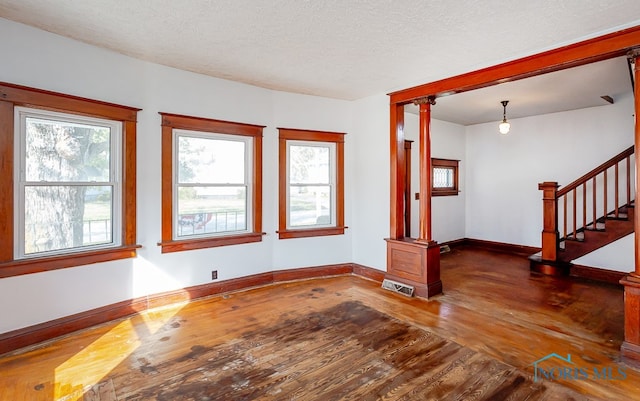 unfurnished living room with hardwood / wood-style floors and a textured ceiling