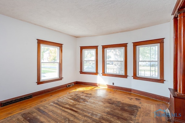 unfurnished room featuring a textured ceiling and hardwood / wood-style flooring