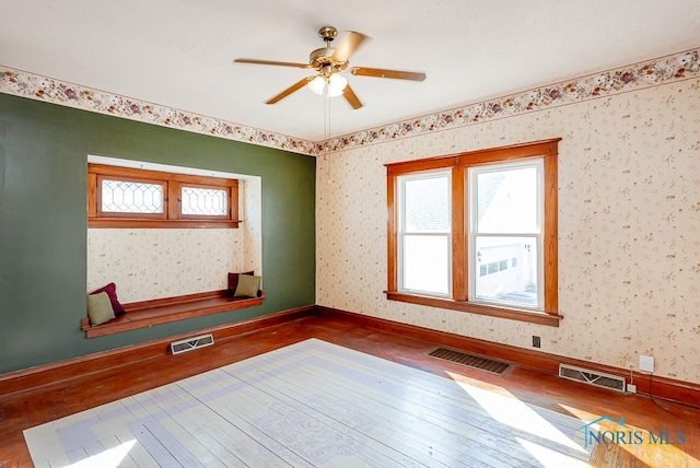 empty room with dark wood-type flooring and ceiling fan