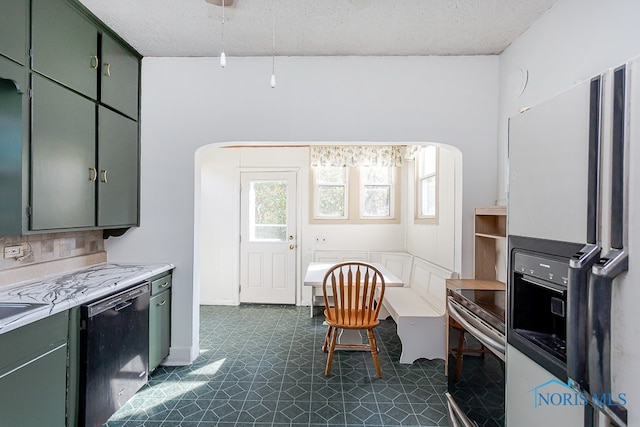 kitchen featuring stainless steel appliances, a textured ceiling, green cabinets, and tasteful backsplash