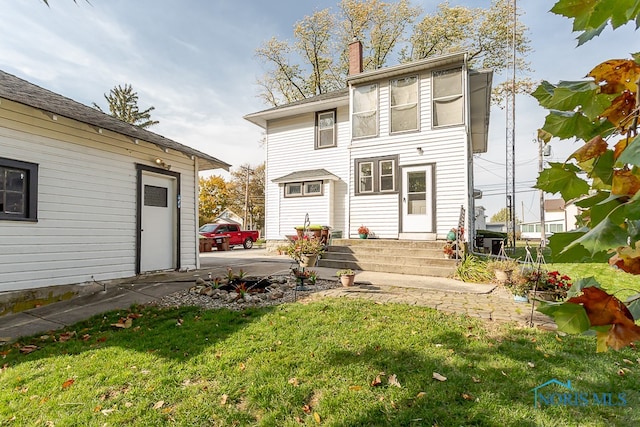 rear view of property with a lawn