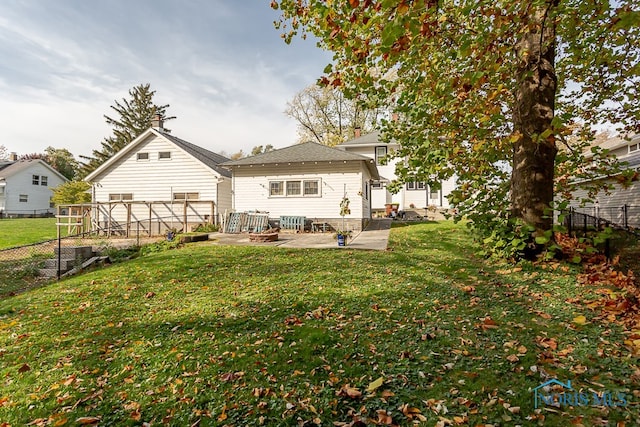 rear view of property featuring a patio and a yard