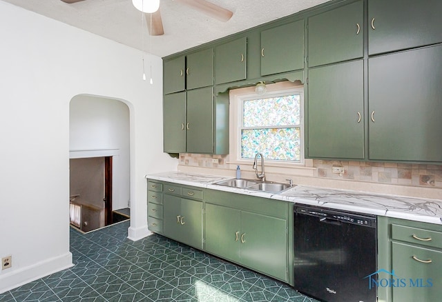 kitchen with black dishwasher, tasteful backsplash, sink, dark tile patterned flooring, and green cabinetry