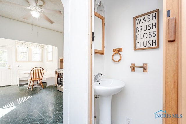 bathroom with ceiling fan, a textured ceiling, and sink