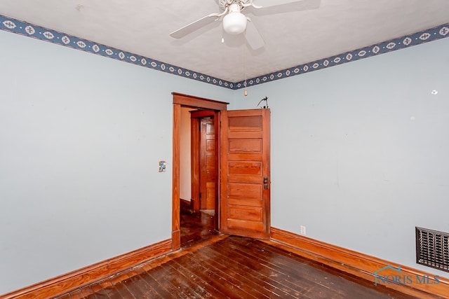 spare room with dark hardwood / wood-style floors and ceiling fan