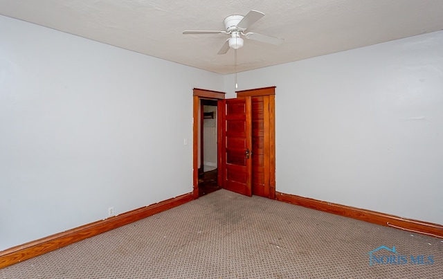 carpeted spare room with ceiling fan and a textured ceiling