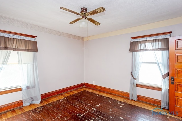 unfurnished room with a textured ceiling, dark hardwood / wood-style floors, and ceiling fan