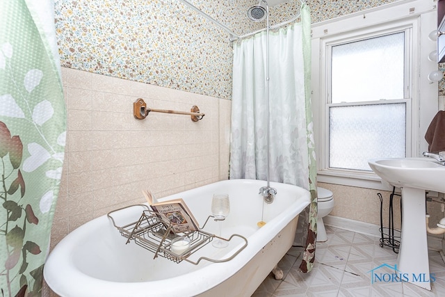 full bathroom featuring toilet, sink, and shower / tub combo with curtain