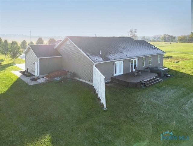 rear view of house featuring a yard and a deck