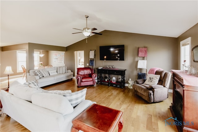 living room with lofted ceiling, hardwood / wood-style floors, and ceiling fan