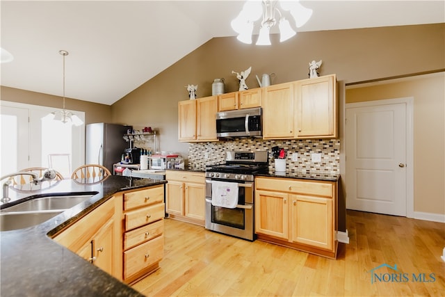 kitchen with sink, light hardwood / wood-style flooring, a notable chandelier, and stainless steel appliances