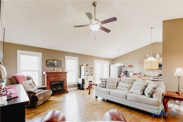 living room featuring a healthy amount of sunlight, light wood-type flooring, and ceiling fan