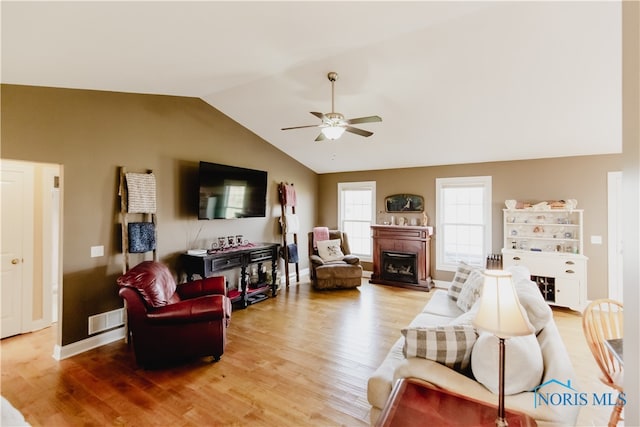 living room with lofted ceiling, wood-type flooring, and ceiling fan