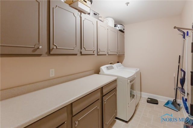 clothes washing area with washer and dryer, light tile patterned flooring, and cabinets