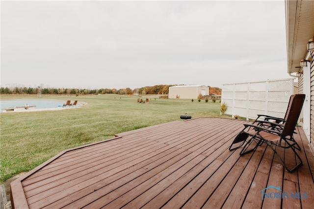 wooden terrace featuring a storage unit and a yard