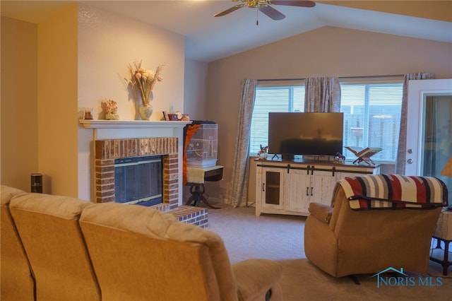 carpeted living room featuring vaulted ceiling, a fireplace, and ceiling fan