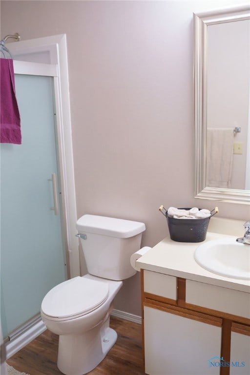 bathroom featuring a shower with door, toilet, wood-type flooring, and vanity