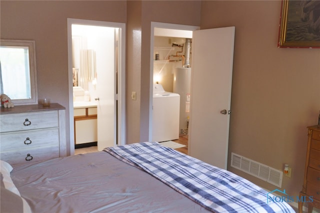 bedroom featuring washer / dryer, ensuite bath, and gas water heater