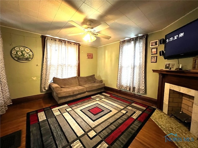 living room featuring hardwood / wood-style flooring, ceiling fan, and ornamental molding