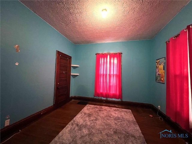 213 E Johnson St, Upper Sandusky, OH 43351 - unfurnished room with a textured ceiling, wood finished floors, and baseboards