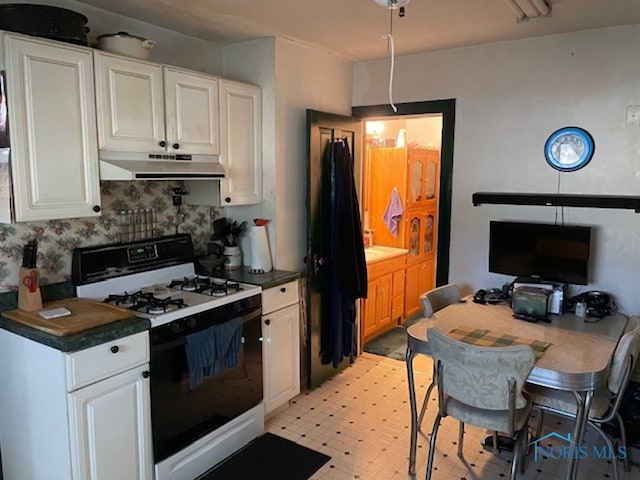 kitchen featuring white cabinets and gas range gas stove