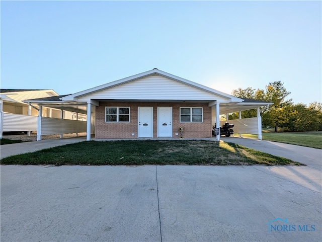 single story home featuring a front yard and a carport