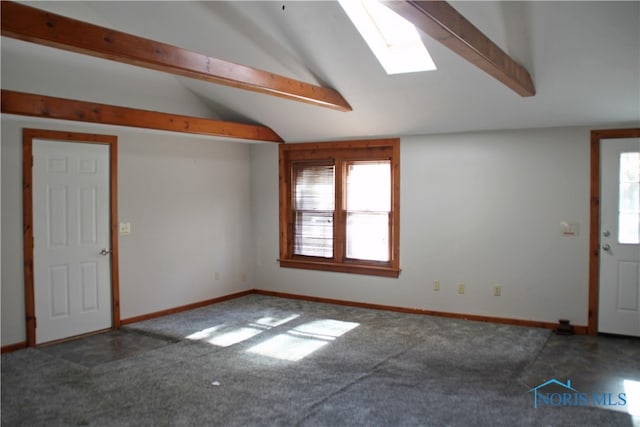 interior space featuring lofted ceiling with skylight and carpet floors