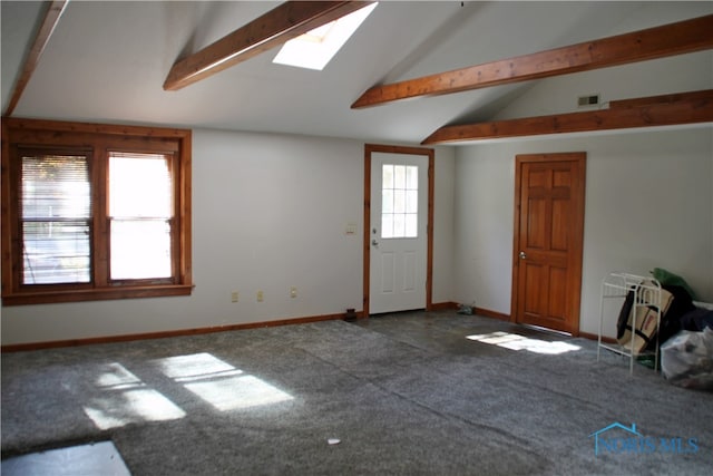 interior space with carpet flooring and vaulted ceiling with skylight