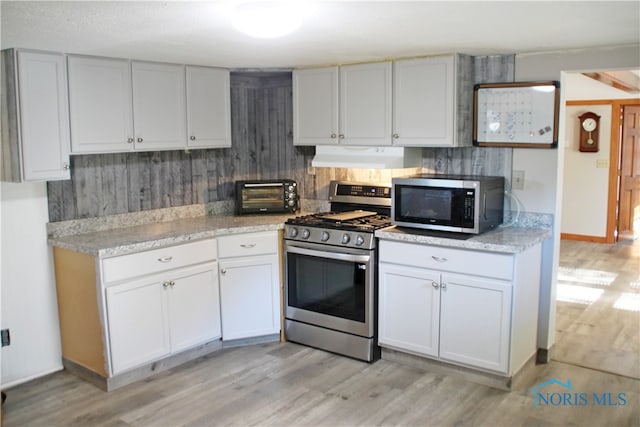 kitchen with white cabinets, stainless steel appliances, and light hardwood / wood-style floors