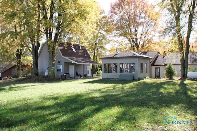 rear view of property with a lawn