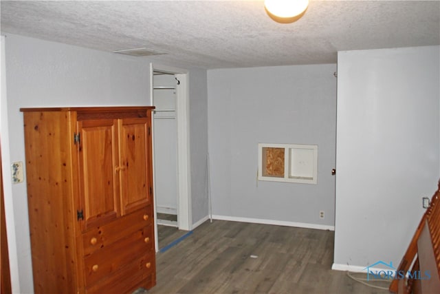 interior space featuring a textured ceiling and dark hardwood / wood-style flooring