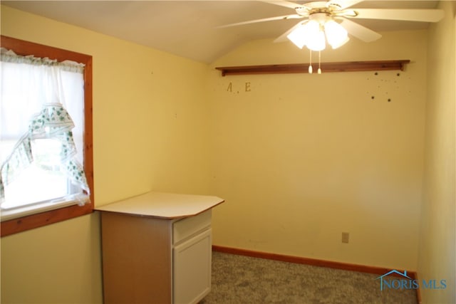 carpeted spare room with ceiling fan and vaulted ceiling