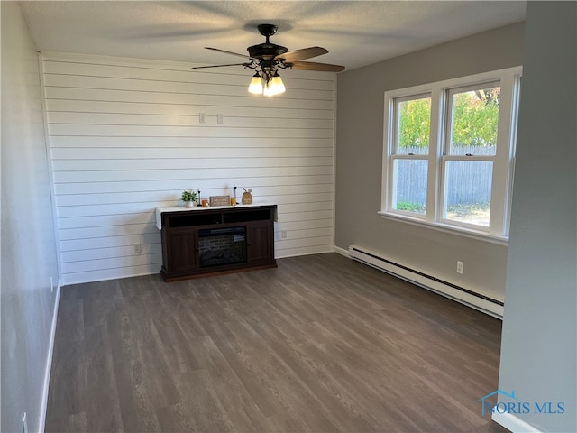 interior space with baseboard heating, ceiling fan, a textured ceiling, and dark hardwood / wood-style flooring