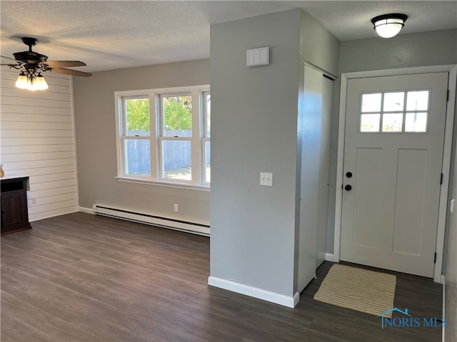 entryway with dark wood-type flooring, ceiling fan, a textured ceiling, and a baseboard heating unit