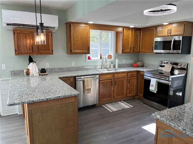 kitchen with sink, appliances with stainless steel finishes, dark wood-type flooring, and pendant lighting