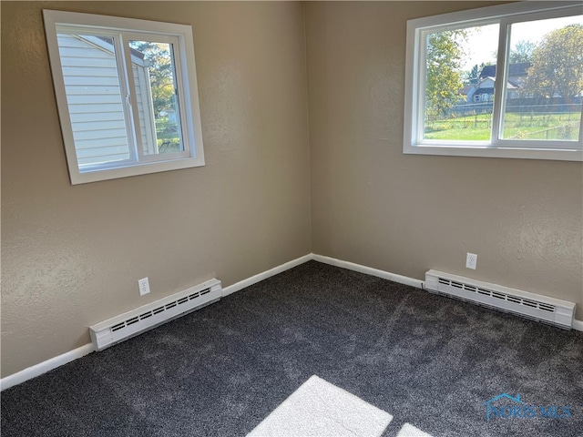 carpeted empty room featuring a baseboard radiator