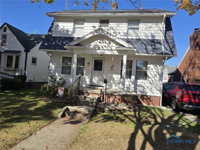 view of front of home with a front yard and covered porch