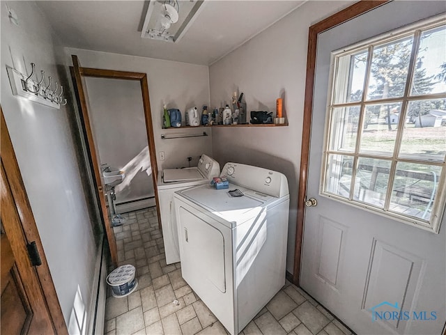 laundry area with sink, a baseboard heating unit, and washing machine and dryer